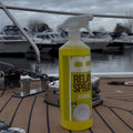 Yellow spray bottle labeled 'Relax Spray' on a boat deck with water and boats in the background