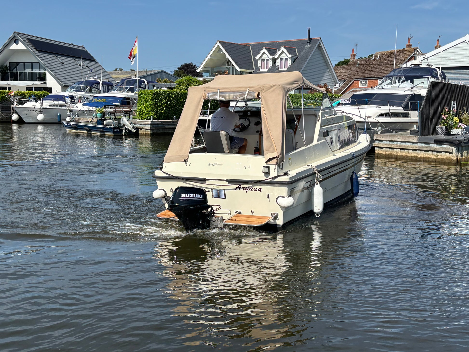 Boat on a dock with houses and flags in the background